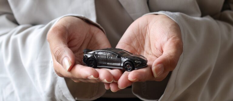 Car toy on palms, car insurance concept