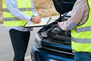 Two men look at a report crash after a collision between cars