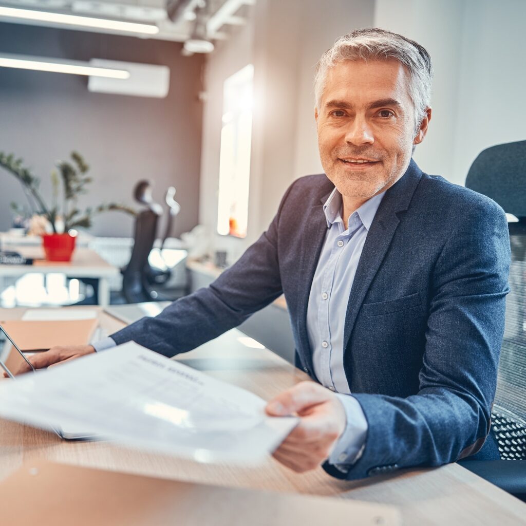 Entrepreneur of company sitting on the chair at his desk and giving a document