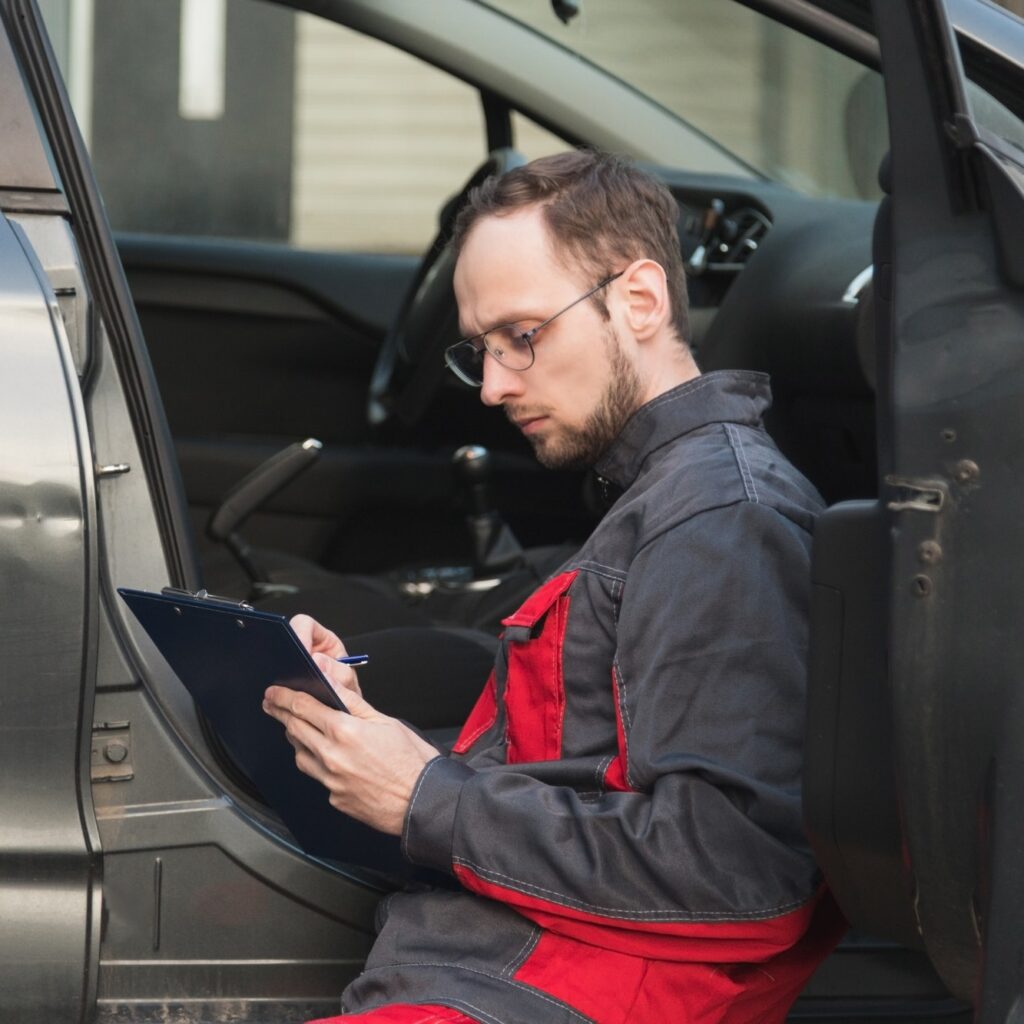 the mechanic checks the door and checks the VIN code of the car, makes notes